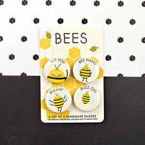 A set of four bee themed badges